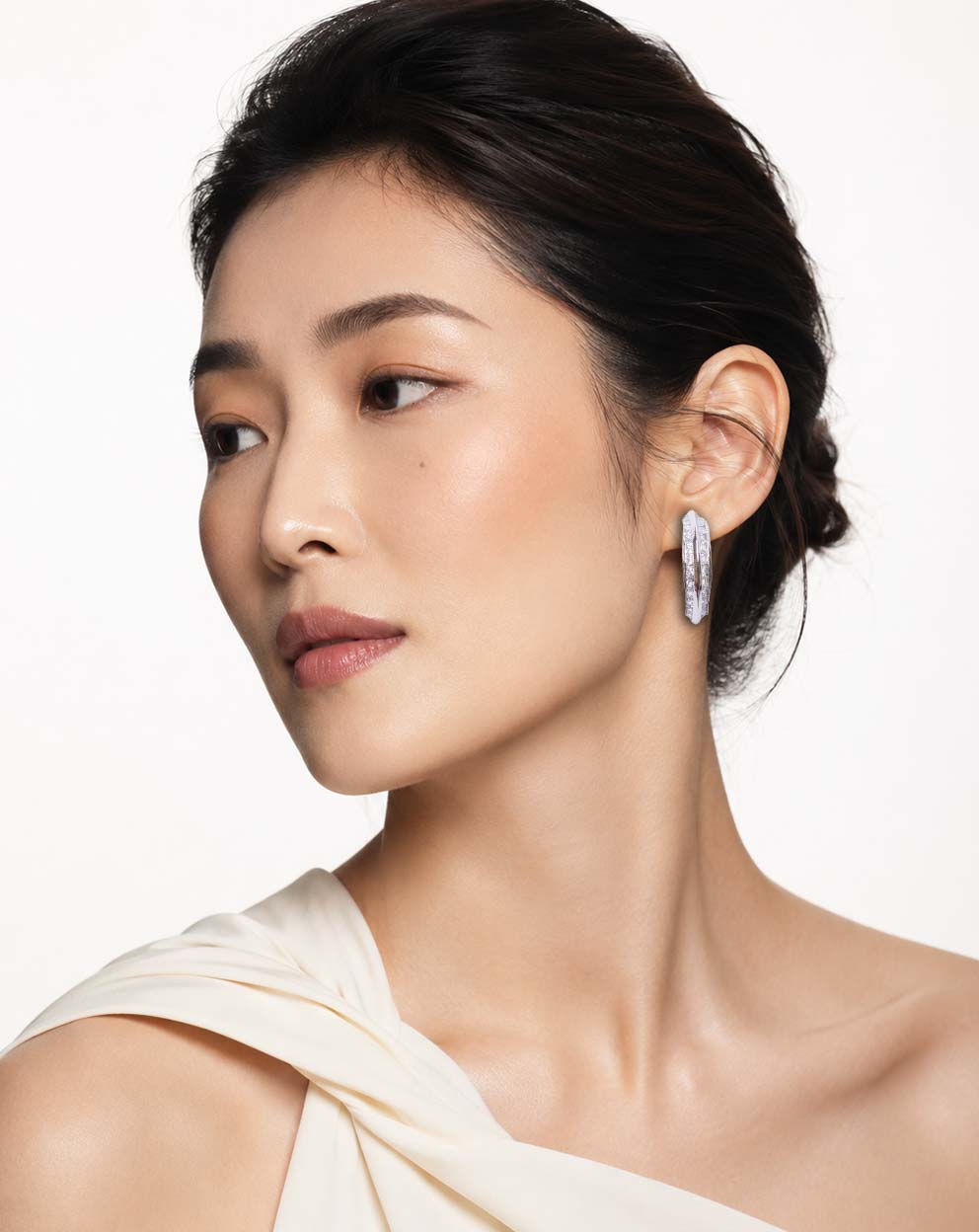 Model wearing a Lumi silver-tone sparkle hoop earring in side profile